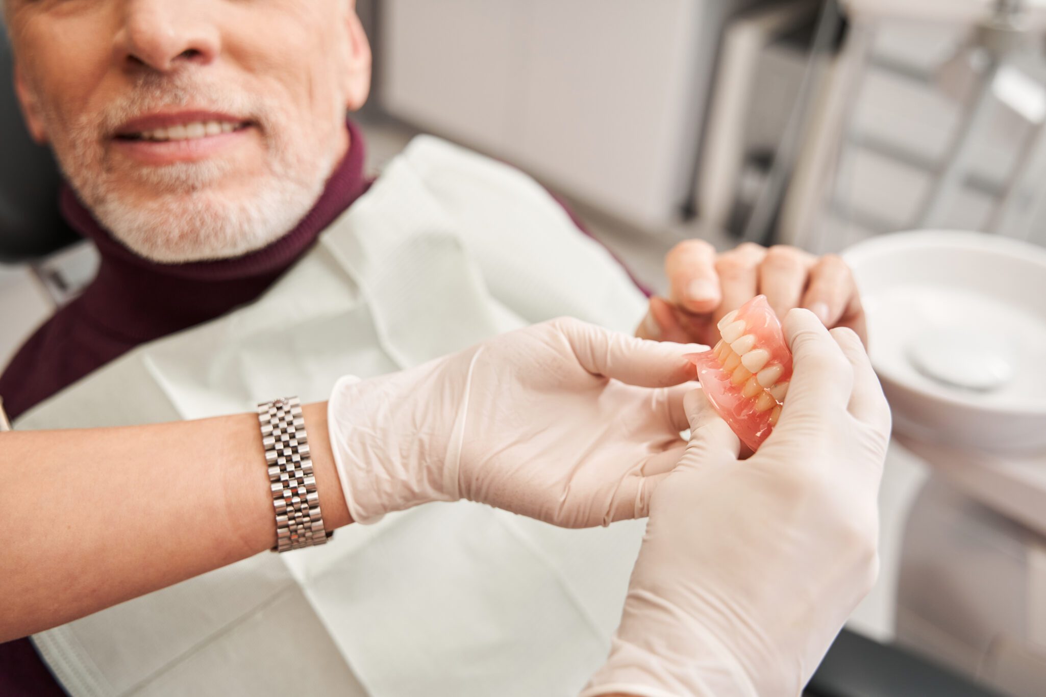 doctor showing a pair of dentures to a patient in Manhattan